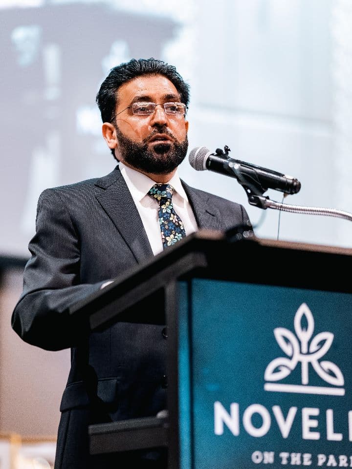Principal Irfan Afzal speaking at a lectern